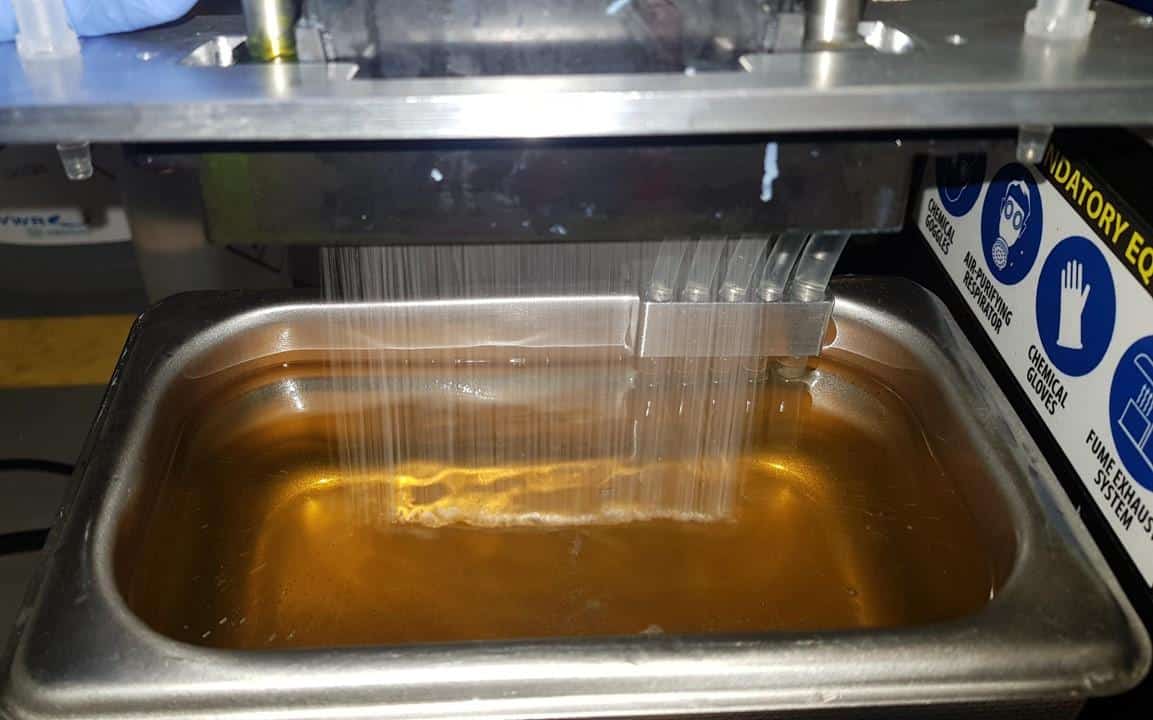 Cleaning print heads of industrial inkjet machines Cabezales de impresión inkjet industrial sumergidos en un baño de ultrasonidos durante el proceso de limpieza