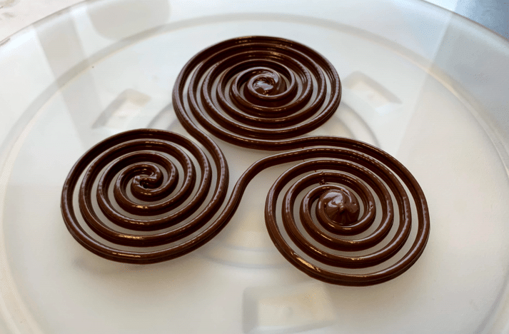 Espirales de chocolate obtenidas por impresión 3D de alimentos sobre un plato