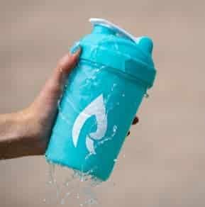 Botella de plástico bajo un chorro de agua durante la comprobación de estanqueidad de una pieza impresa en 3D