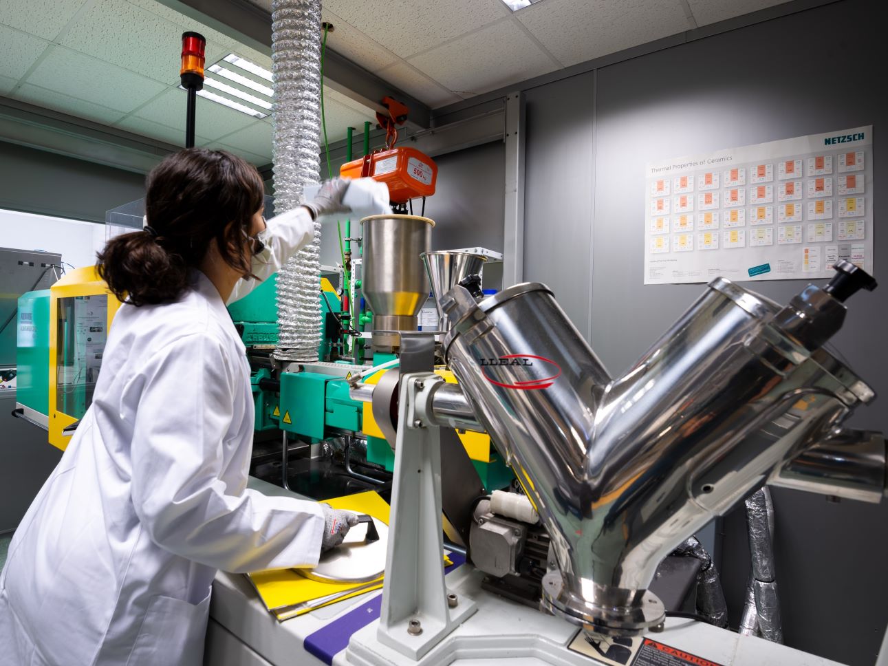 Ensayos de plásticos y polímeros Técnica de INFINITIA preparando material polimérico en el laboratorio de inyección