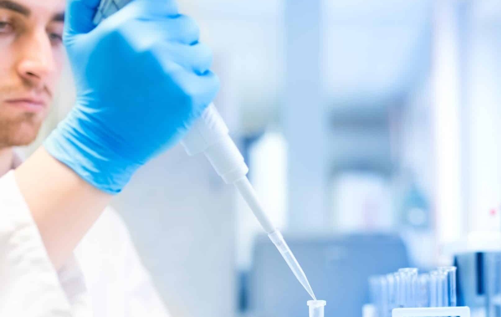 Técnico de laboratorio pipeteando una muestra durante un análisis