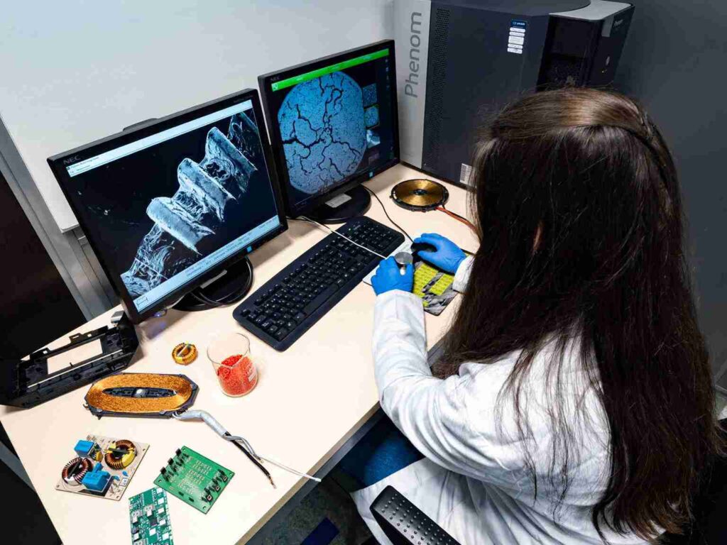 Ingeniera analizando componentes electrónicos para detectar fallos mediante ingeniería forense