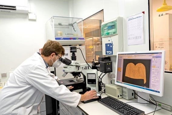 Ingeniero analizando microestructura de material mediante microscopía en laboratorio industrial