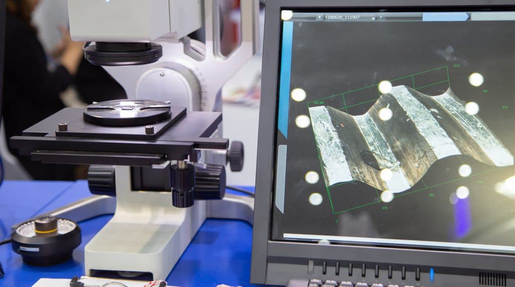 Microscope analyzing the surface of a material to characterize a part before replicating a component