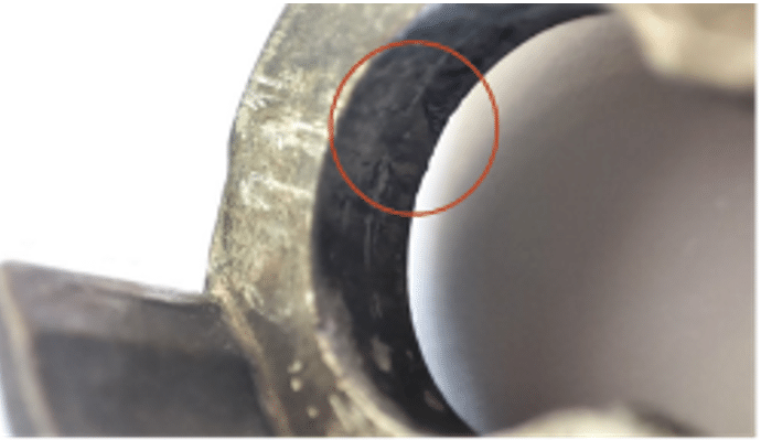 Close-up of marks and deformations on metal hinges indicating possible causes of failure