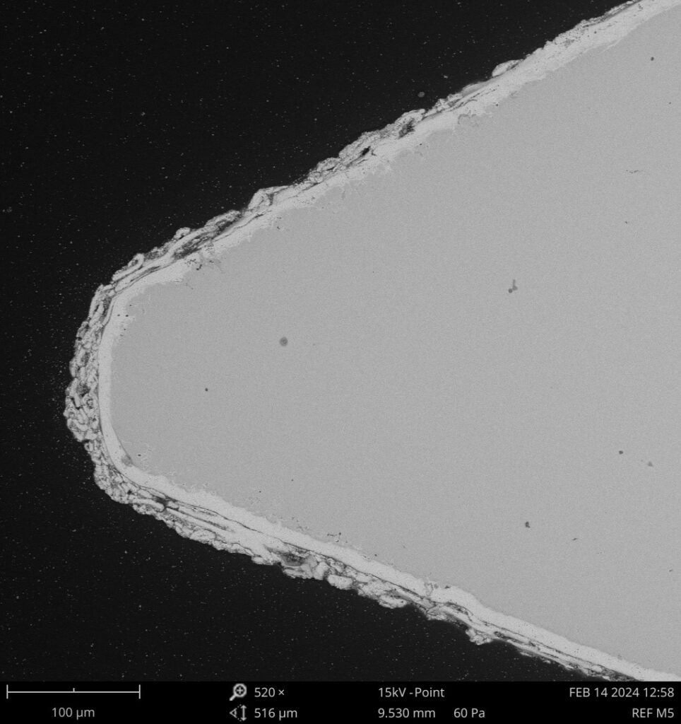 Detalle microestructural de recubrimiento en componente electrónico observado con microscopía para análisis de materiales y defectos