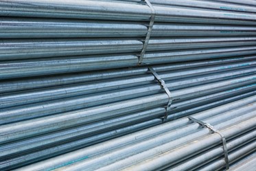 Stack of galvanized steel tubes in an industrial setting