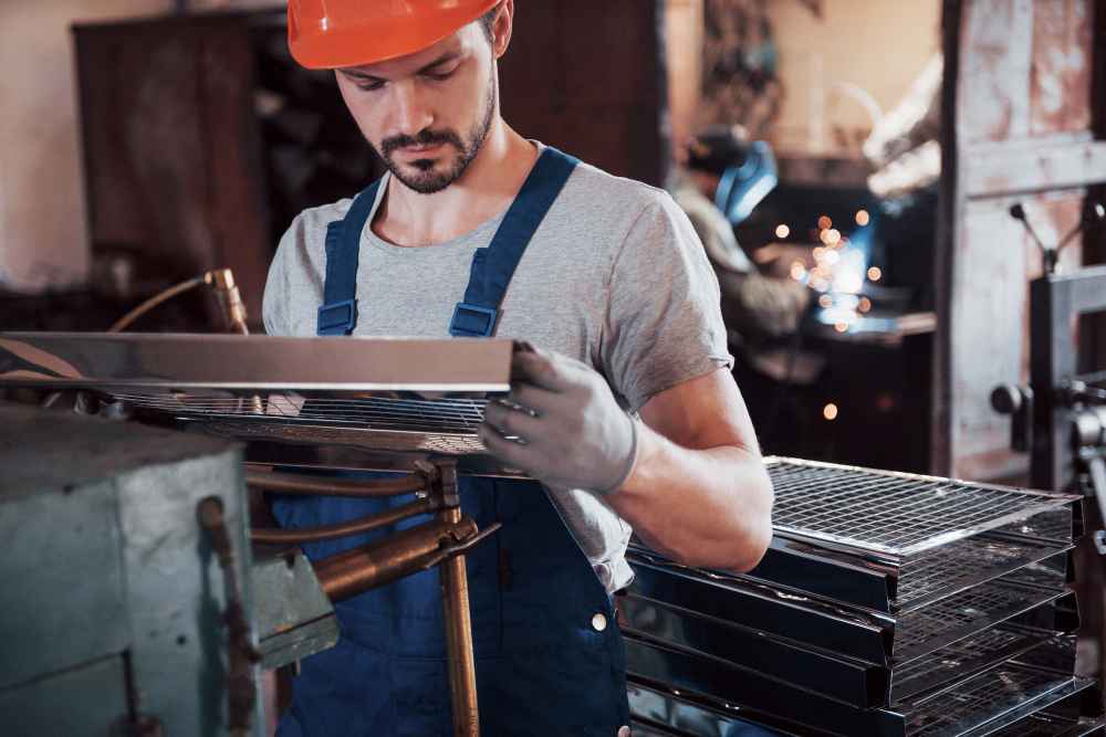 Operator inspecting metal parts during quality control in an industrial manufacturing process