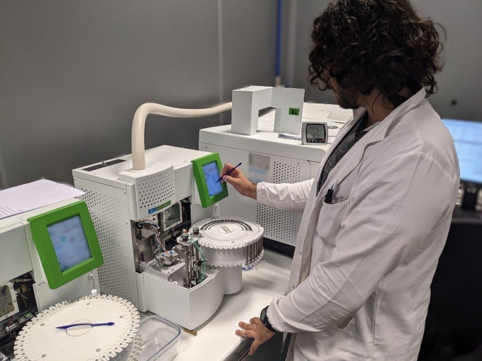 Technician performing paint chemical analysis using chromatography equipment in laboratory