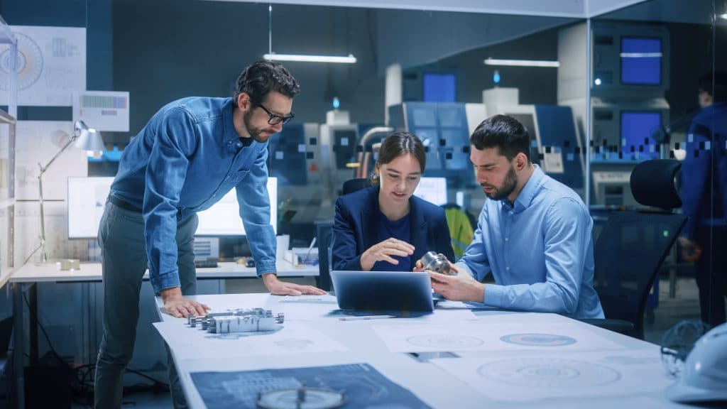 Diseño e innovación Ingenieros revisando prototipo y planos en proyecto de diseño e innovación industrial