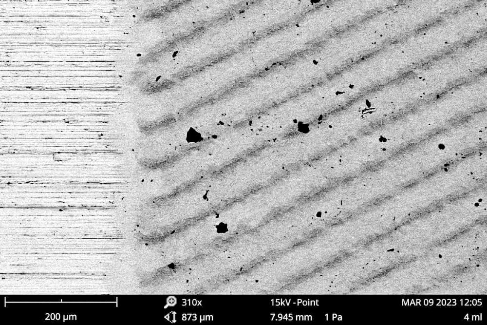 Imagen de microscopía electrónica de barrido del acero inoxidable mostrando microestructura superficial y partículas tras exposición a altas temperaturas