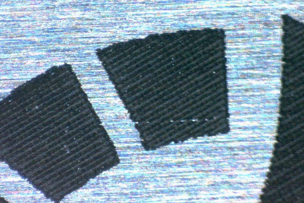 Microscopic image of stainless steel showing surface oxidation areas associated with thermal-induced yellowing