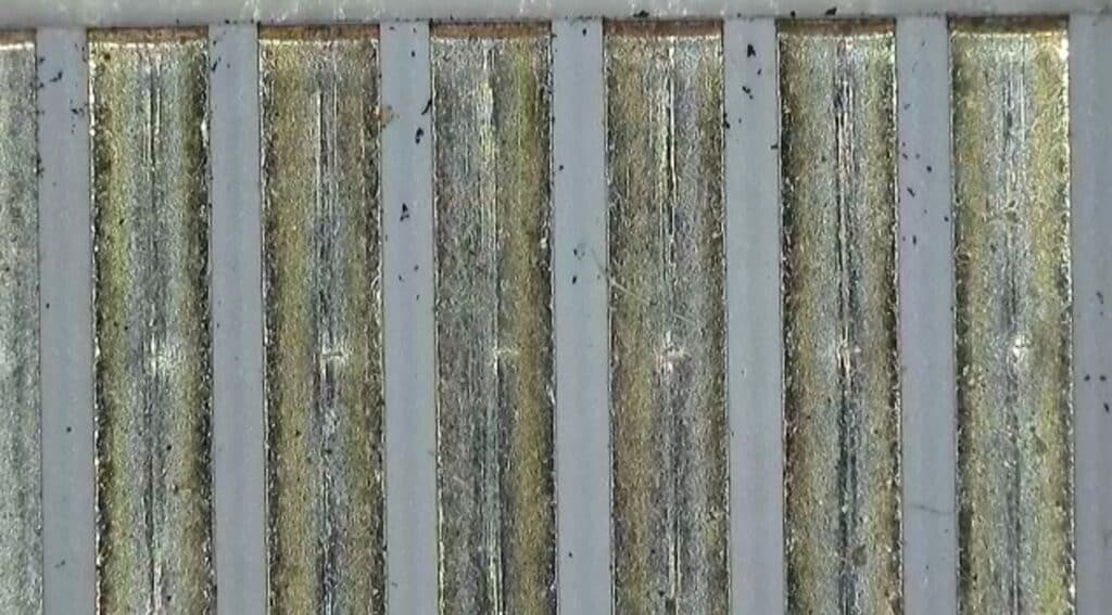 Estudio del modo de fallo Imagen microscópica de residuos desconocidos detectados en un componente eléctrico durante un análisis de fallos