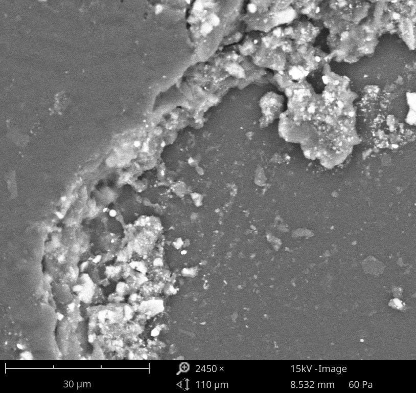 Imagen SEM mostrando partículas contaminantes en la superficie de aluminio responsables de defectos de pintura en el recubrimiento