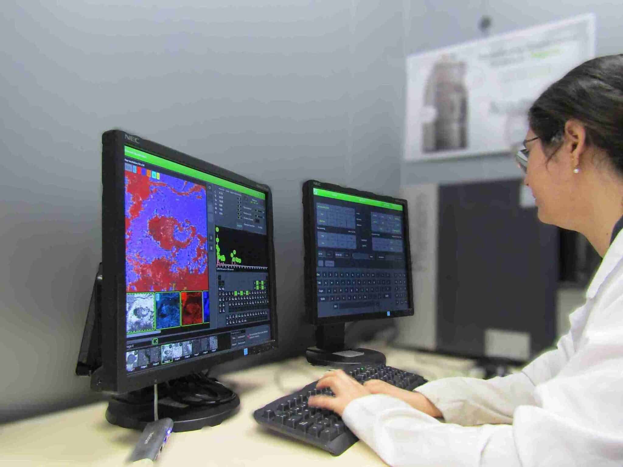 Técnica de laboratorio analizando mapa de composición elemental EDX obtenido por microscopía electrónica de barrido SEM en doble pantalla