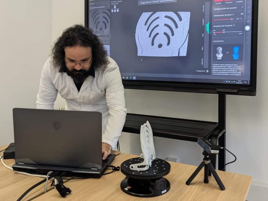 Escaneado 3D y digitalización de piezas Técnico de Infinitia configurando parámetros de escaneado 3D sobre plataforma giratoria para ingeniería inversa de componente industrial