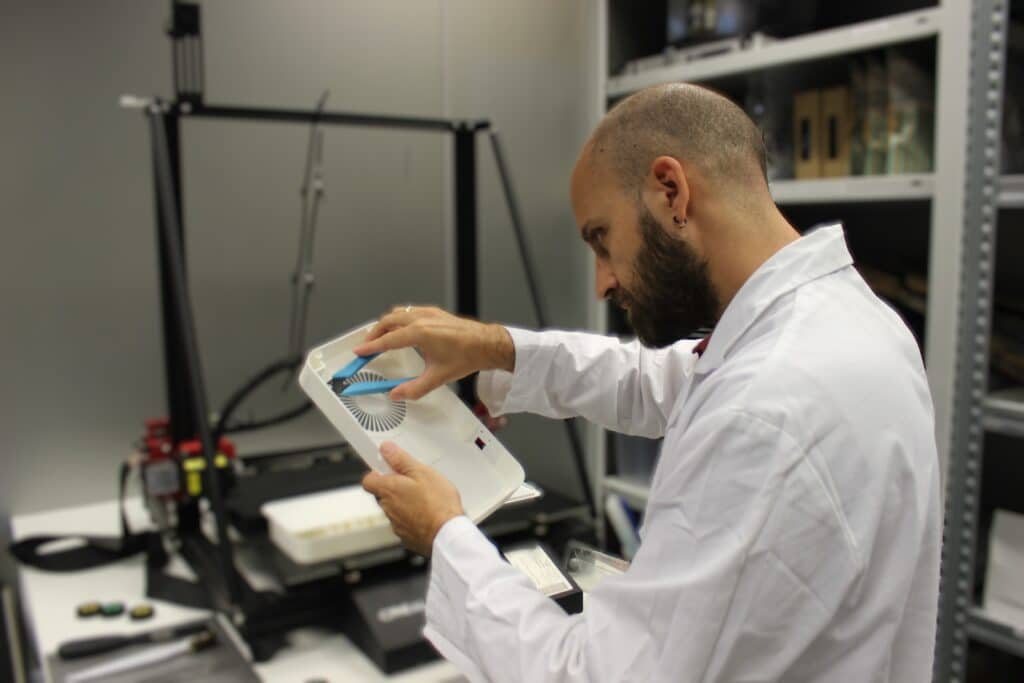 Diseño para fabricación Técnico de Infinitia inspeccionando prototipo fabricado por impresión 3D ante impresora FDM en laboratorio