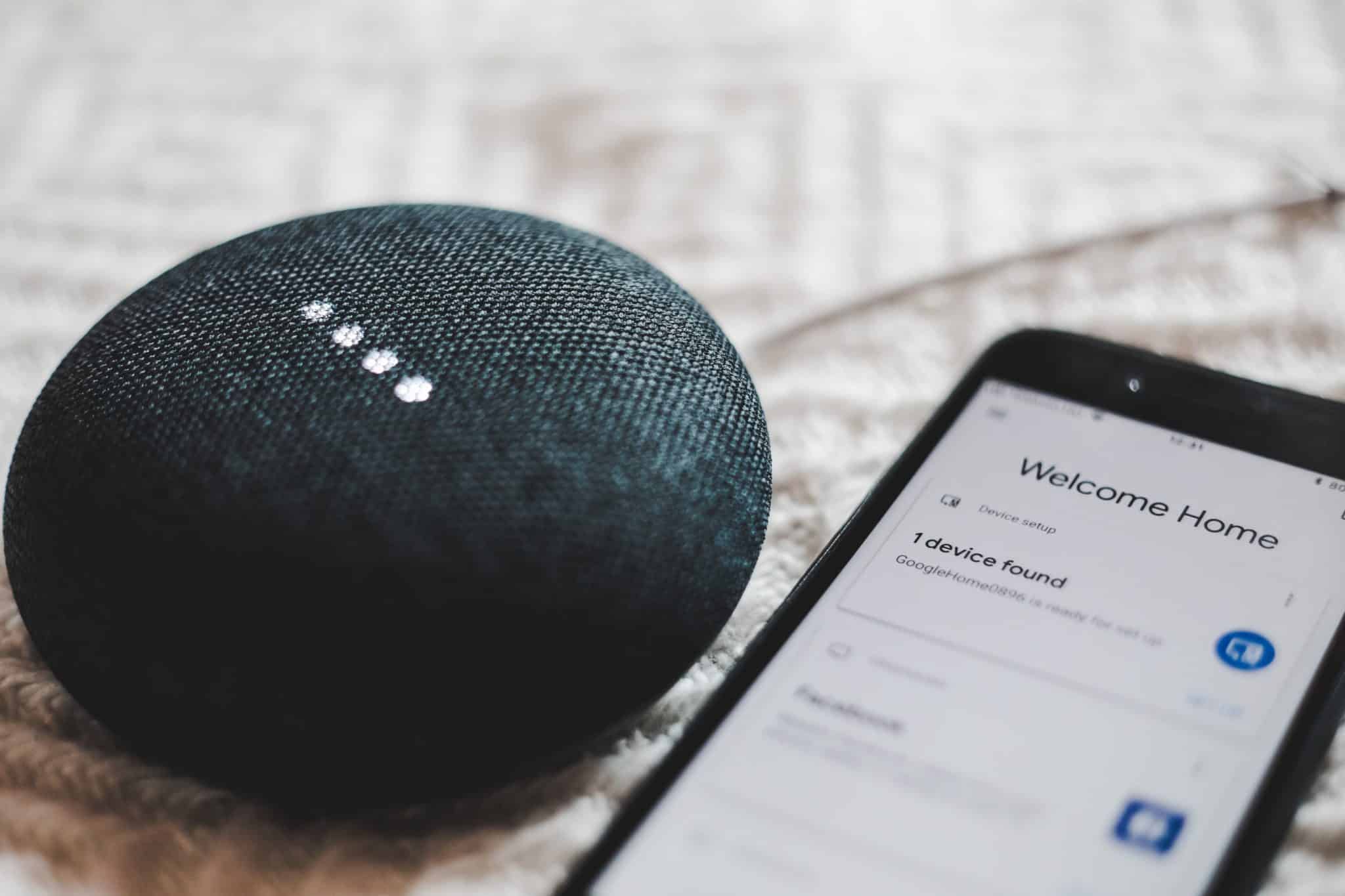 Smart speaker next to a phone with a control app