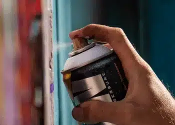 New ways to color metal by laser decoration Hand applying spray paint to a surface
