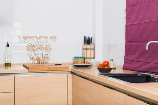 Cocina doméstica con encimera, fregadero y utensilios, contexto del diseño de un producto para mejorar el reciclaje en el hogar