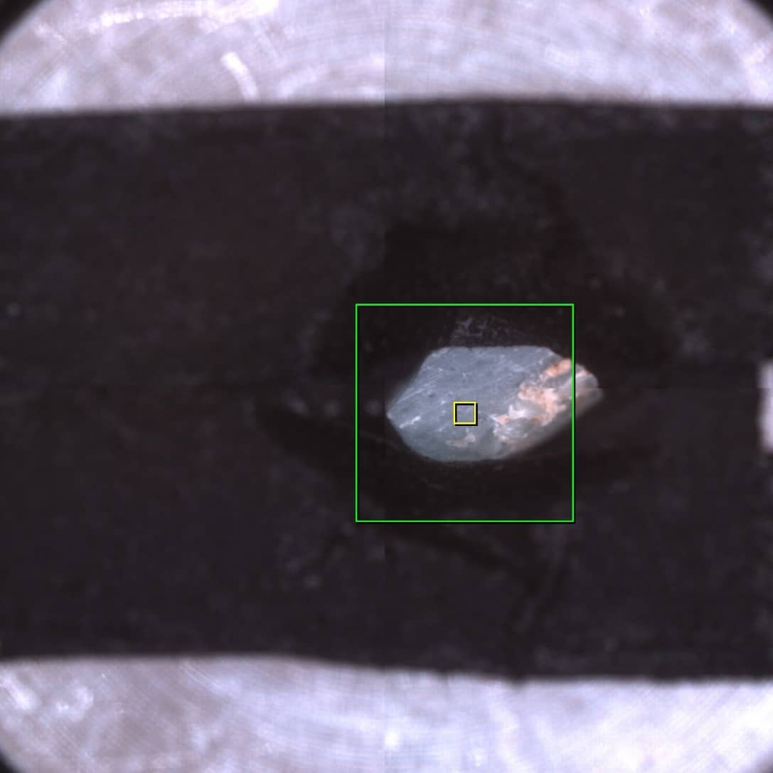 Micrografía con las zonas de análisis marcadas sobre una partícula en una sección pulida