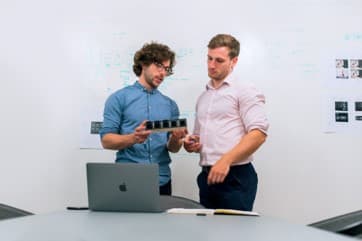 3D printing to detect design flaws in leak-tight parts Two engineers discussing a design next to a laptop