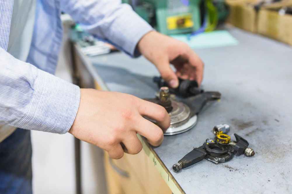 Technician inspecting mechanical components to detect potential failures in industrial products