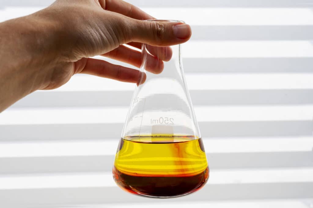 Industrial oil sample in a laboratory flask used for physicochemical analysis and quality evaluation.