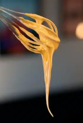 Whisk coated with a creamy food batter