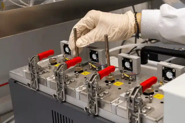 Chemical analysis of metallic components and evaluation of their toxicity Technician handling a multi cell sample preparation system for chemical analysis