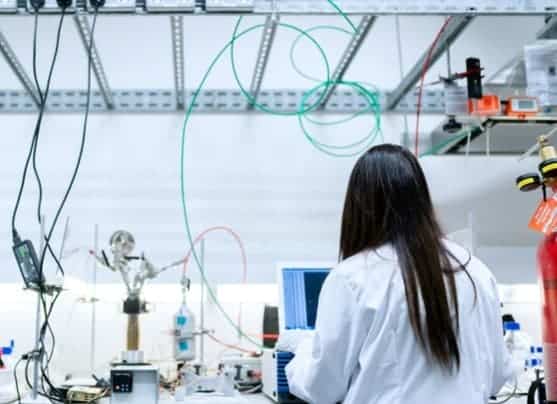 Laboratory technician working at a test bench with tubing and measuring equipment